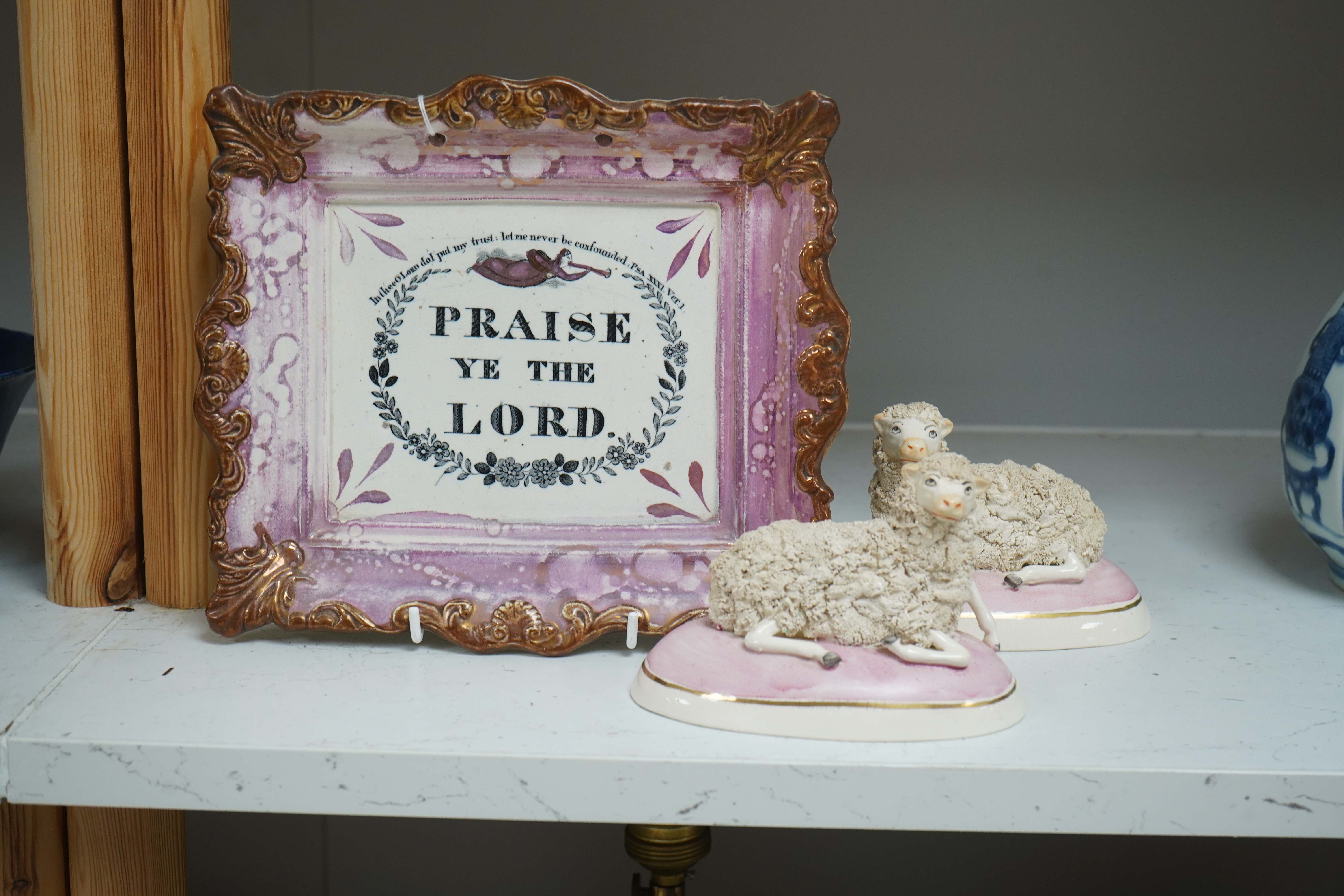 An 19th century Sunderland pink lustre wall plaque and two Staffordshire-style models of recumbent sheep, dish 24cm wide. Condition - good